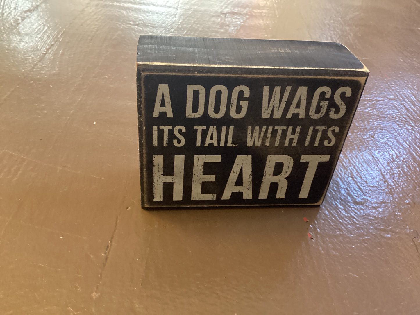 A dog wags it’s tail with it’s heart box sign